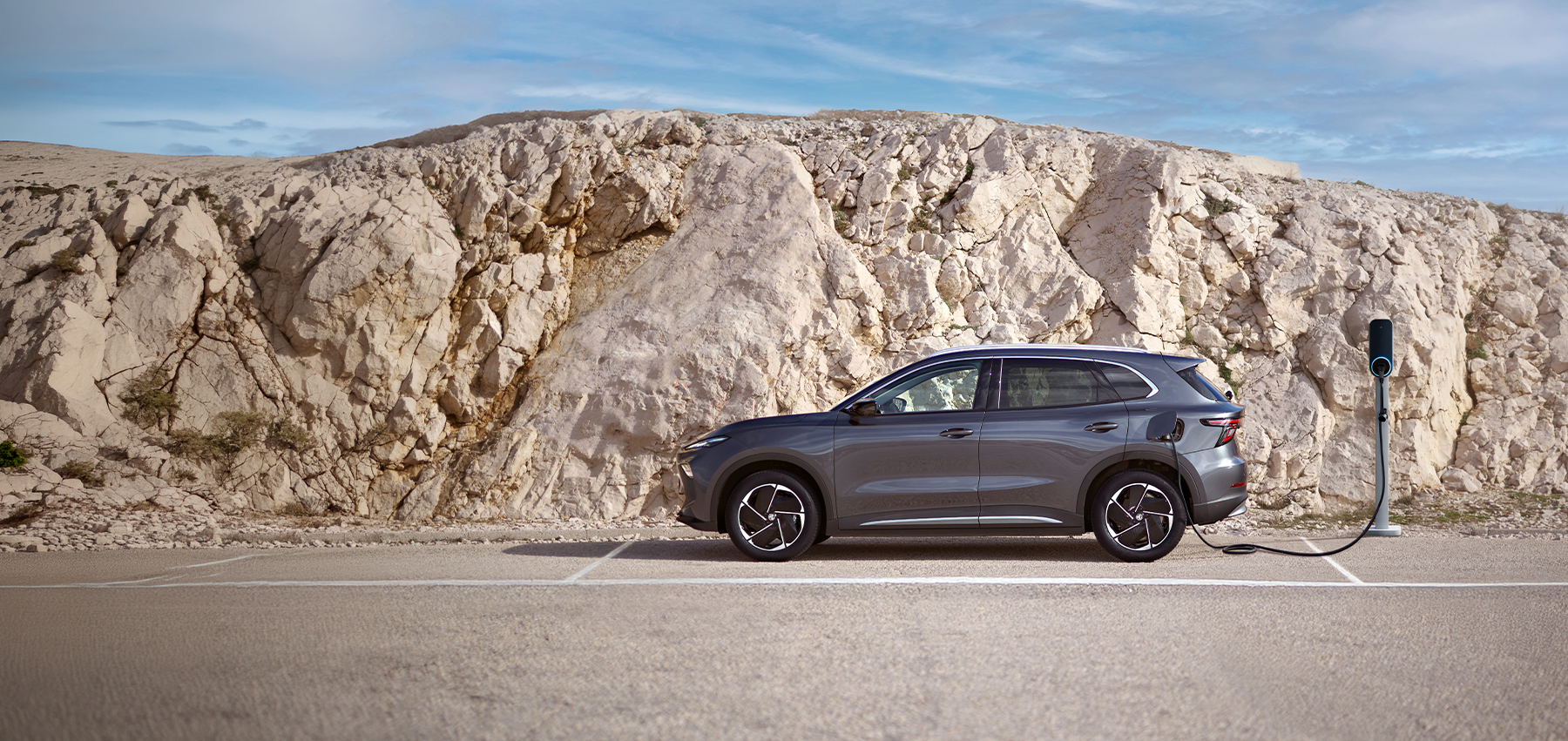 MG S5 EV parkert ved ladestasjon foran lyst fjellandskap
