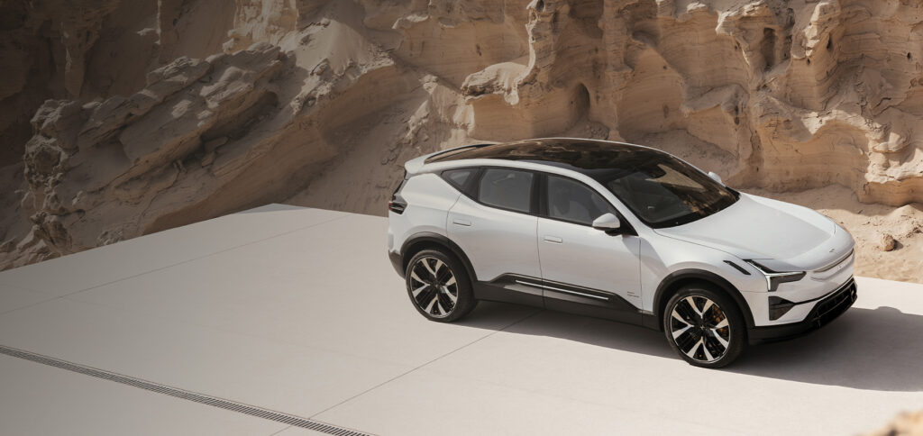 Hvit Polestar 3 parkert foran sandfarget fjellformasjon