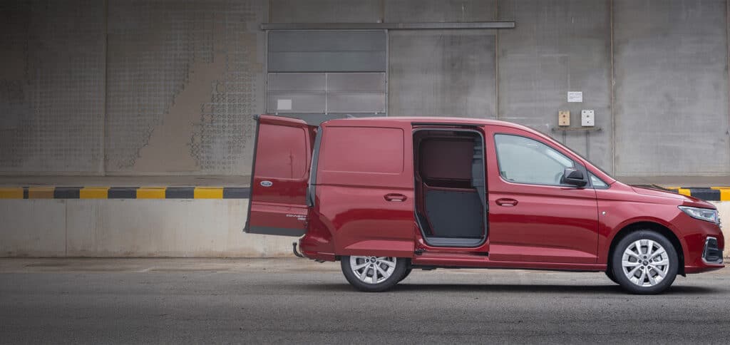 Rød Ford Transit Connect varebil med åpne bakdører og skyvedø