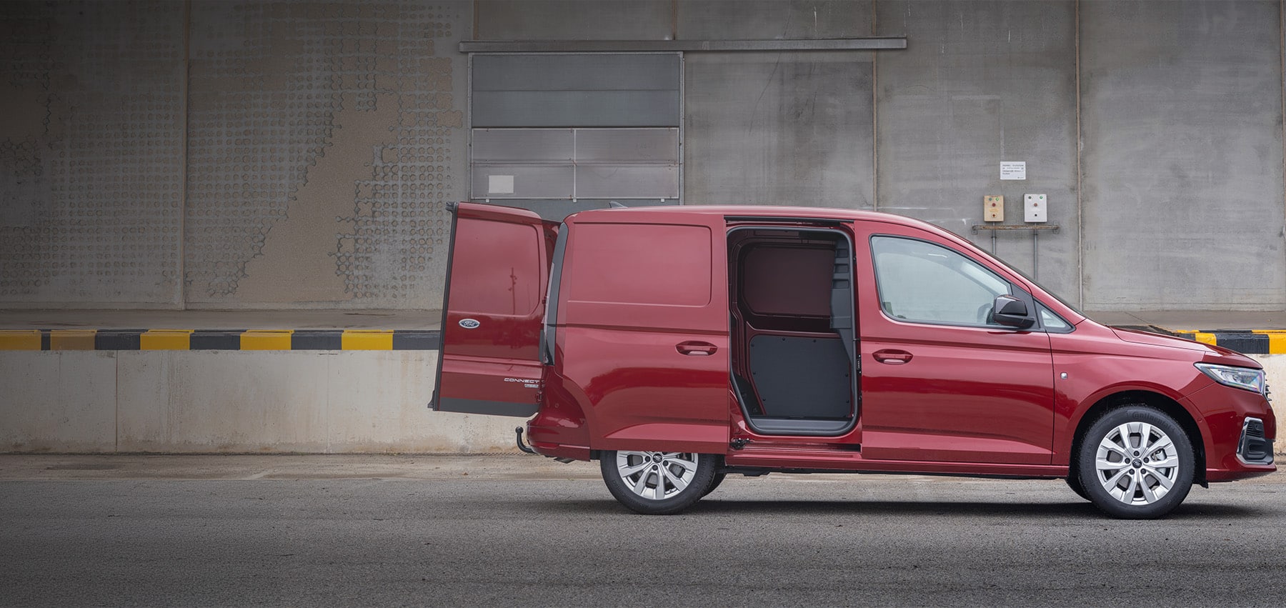 Rød Ford Transit Connect varebil med åpne bakdører og skyvedø