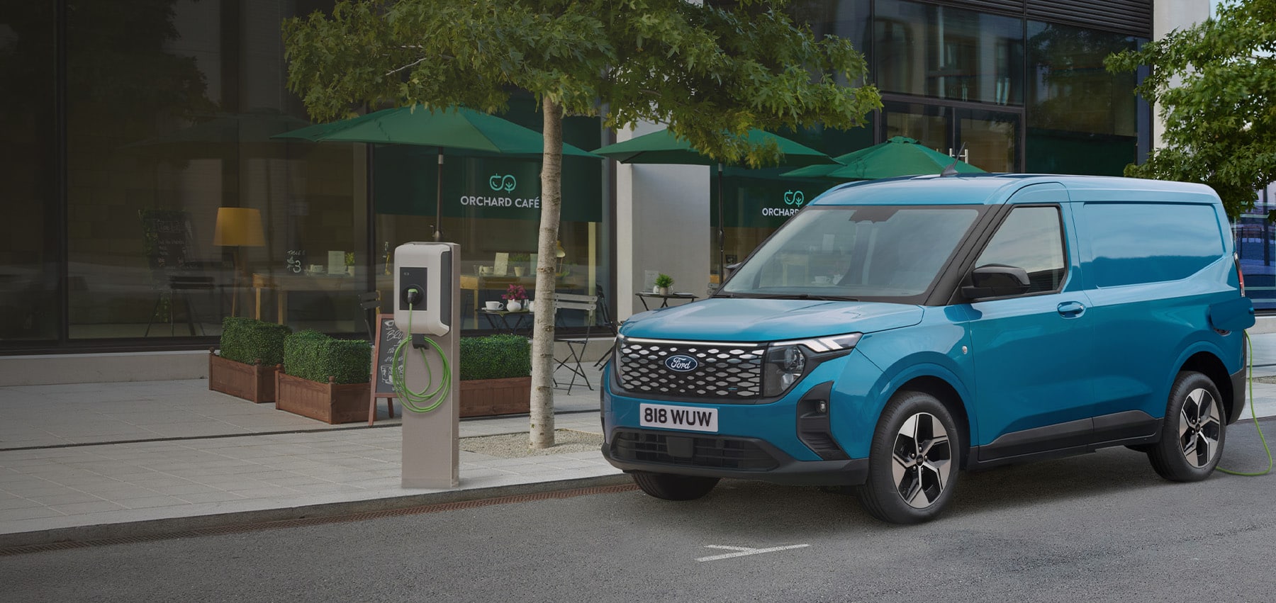 Blå Ford E-Transit Courier lader i urbant bymiljø