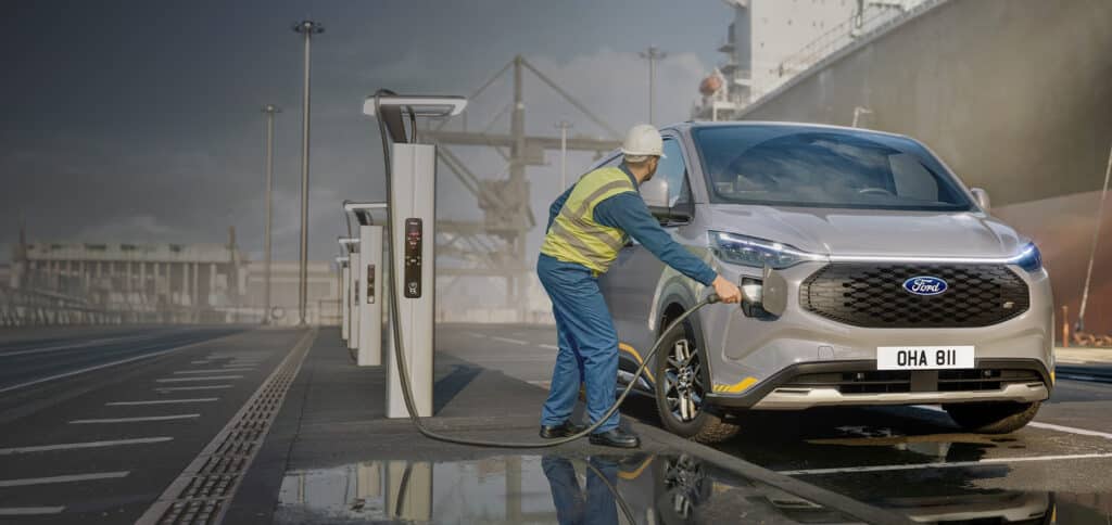 Ford E-Transit Custom lades ved havn med arbeider i refleksvest
