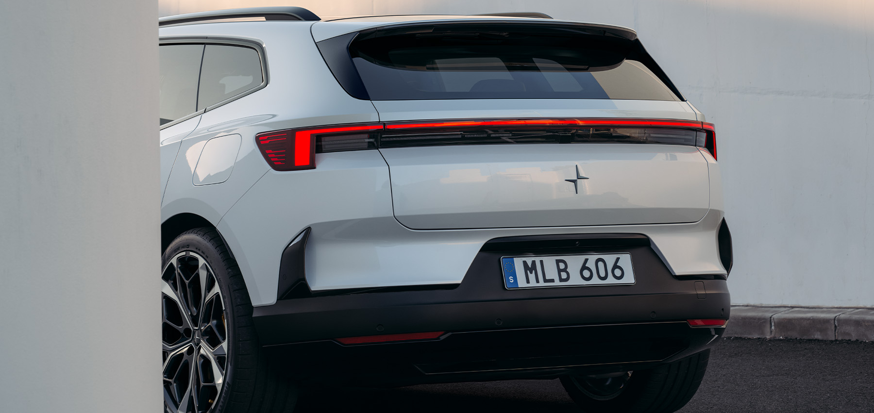 Bakfra av hvit Polestar 4 SUV med karakteristisk LED-lysdesign
